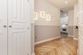 Hallway of a vacation rental house with a built-in closet with white wooden doors and beautiful pine wood flooring