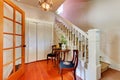 Hallway with white staircase and hardwood floor.