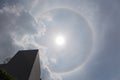 The halo around the sun with cloudy sky and building skyline, na