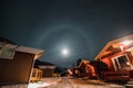 The halo effect of the moon in the northern Norwegian city of Tromso among the red typical huts. A moon sighting. far beyond the Royalty Free Stock Photo