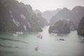 Halong bay traditional fishing boats, UNESCO world natural heritage, Vietnam. Tourist cruise ships sailing among limestone