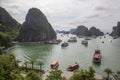 Halong bay traditional fishing boats, UNESCO world natural heritage, Vietnam. Tourist cruise ships sailing among limestone