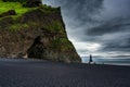 Halsanefshellir cave with Reynisdrangar natural rock formation on Reynisfjara black sand beach in gloomy day at Iceland