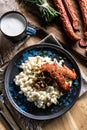 Halusky as traditional Slovak potato gnocchi with sheep cheese bryndza, fried bacon,sausage and chives Royalty Free Stock Photo