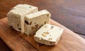 Halva almond nuts slices on wooden table background