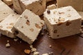 Halva almond nuts slices on wooden table background