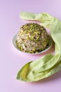 Halva with chopped pistachios and green napkin on pink