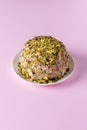 Halva with chopped pistachios on pink with copy space