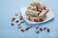 Halva made from sunflower seeds, almonds and pistachios lies on a plate against a blue background. Pistachios and almonds are Royalty Free Stock Photo