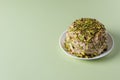 Halva with pistachios on green background with copy space
