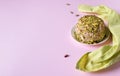 Halva with pistachios nuts and napkin on pink background