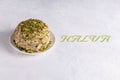 Halva with pistachios on white background with green text