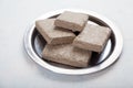 Halva from sunflower seeds in briquettes in a metal plate stands on a white background Royalty Free Stock Photo