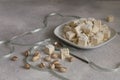 Halvah in plate with pistachios nuts with gray ribbon on gray background