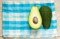 Halved avocados on rustic wooden background