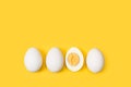 Halved boiled egg and three eggs on a yellow background Royalty Free Stock Photo