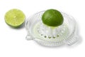 Halved fresh lime and a glass juicer close up on white background
