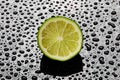 Halved fresh lime on a wet black background