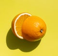 Halved fresh orange on the bright yellow surface Royalty Free Stock Photo