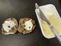 A halved hot cross bun with a pot of butter. Royalty Free Stock Photo