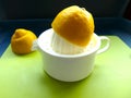 Halved lemon is juiced on a lemon press. Cut out, close up