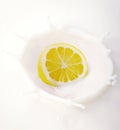 Halved lemon splashing into milk