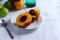 Halved nectarine on white plate