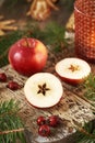 Halved red apple with a star in the middle, with Christmas decoration and rose hips Royalty Free Stock Photo