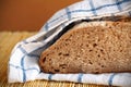 Halved rye bread loaf wrapped in the kitchen towel
