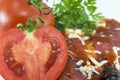 Halved tomato with slice of pizza and parsley in background Royalty Free Stock Photo