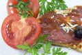 Halved tomato with slice of pizza and parsley in background Royalty Free Stock Photo