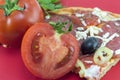 Halved tomato with slice of pizza and parsley in background Royalty Free Stock Photo