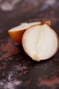 A halved onion on a black metal surface background