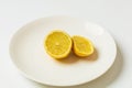Halved yellow lemon on a white plate Royalty Free Stock Photo