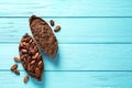 Halves of cocoa pod with beans and powder on wooden table, top view. Space for text Royalty Free Stock Photo