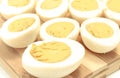 Halves of cooked eggs on wooden cutting board Royalty Free Stock Photo