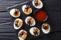 Halves devilish eggs decorated with olive spiders close-up serve