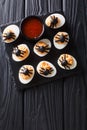 Halves devilish eggs decorated with olive spiders close-up serve