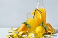 Halves of fresh orange, lemon, glass of orange juice, bottle of orange juice, measuring tape, citrus, fruit juice Royalty Free Stock Photo