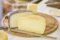 Halves hard cheese heads on wooden market board. Gastronomic dairy produce, real scene in the food market Royalty Free Stock Photo