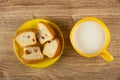 Halves of muffins with raisin in saucer, cup of milk on wooden table. Top view Royalty Free Stock Photo