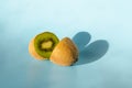 Halves of one kiwi with a shadow in the form of a heart on a blue background. Minimalism. St. Valentine\'s Day