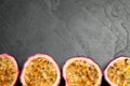 Halves of passion fruits maracuyas on slate table, flat lay. Space for text Royalty Free Stock Photo