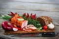 Ham and bread sliced with knife. Green and red vegetables on chopping board