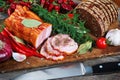 Ham and bread sliced with knife. Green and red vegetables on chopping board Royalty Free Stock Photo