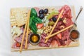 Ham, cheese, grapes, figs, nuts, bread ciabatta, cracker, jam on white wooden board on bright wooden surface. Rustic style. Royalty Free Stock Photo