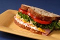 Ham, cheese, lettuce and tomato sandwich on yellow plate Royalty Free Stock Photo