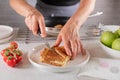 Ham and cheese sandwich is cut in half by woman hand with a knife Royalty Free Stock Photo
