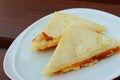 Ham and cheese sandwich on a white plate.