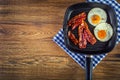 Ham and Egg. Bacon and Egg. Salted egg and sprinkled with black pepper. Grilled bacon, two eggs in a Teflon pan Royalty Free Stock Photo